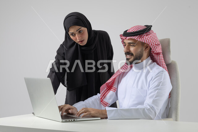  الوحده والعمل الجماعي، تبادل الاراء والخبرات، بورتريه لرجل وسيدة اعمال عربيان سعوديان خليجيان في مقر الشركة، ادارة العمل باستخدام الحاسب المحمول، تحقيق اهداف الشركة، مناقشة وتوزيع مهام العمل، تطوير العمل وحل المشكلات، مهن ووظائف سعودية مكتبية، خلفية بيضاء