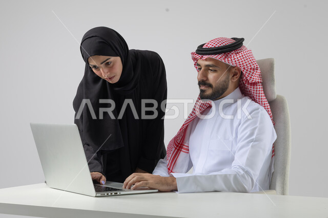  الوحده والعمل الجماعي، تبادل الاراء والخبرات، بورتريه لرجل وسيدة اعمال عربيان سعوديان خليجيان في مقر الشركة، ادارة العمل باستخدام الحاسب المحمول، تحقيق اهداف الشركة، مناقشة وتوزيع مهام العمل، تطوير العمل وحل المشكلات، مهن ووظائف سعودية مكتبية، خلفية بيضاء