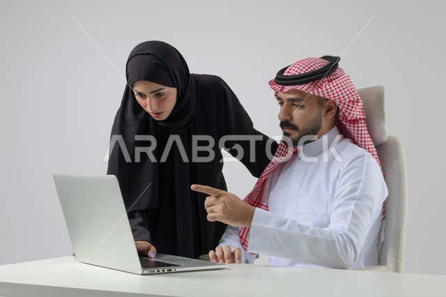  الوحده والعمل الجماعي، تبادل الاراء والخبرات، بورتريه لرجل وسيدة اعمال عربيان سعوديان خليجيان في مقر الشركة، ادارة العمل باستخدام الحاسب المحمول، تحقيق اهداف الشركة، مناقشة وتوزيع مهام العمل، تطوير العمل وحل المشكلات، مهن ووظائف سعودية مكتبية، خلفية بيضاء