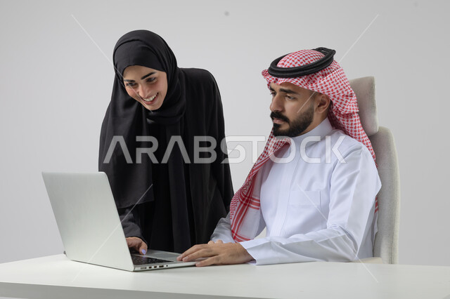  الوحده والعمل الجماعي، تبادل الاراء والخبرات، بورتريه لرجل وسيدة اعمال عربيان سعوديان خليجيان في مقر الشركة، ادارة العمل باستخدام الحاسب المحمول، تحقيق اهداف الشركة، مناقشة وتوزيع مهام العمل، تطوير العمل وحل المشكلات، مهن ووظائف سعودية مكتبية، خلفية بيضاء