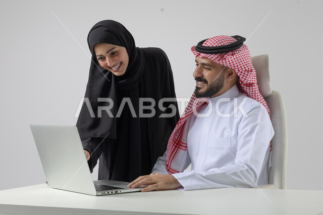  الوحده والعمل الجماعي، تبادل الاراء والخبرات، بورتريه لرجل وسيدة اعمال عربيان سعوديان خليجيان في مقر الشركة، ادارة العمل باستخدام الحاسب المحمول، تحقيق اهداف الشركة، مناقشة وتوزيع مهام العمل، تطوير العمل وحل المشكلات، مهن ووظائف سعودية مكتبية، خلفية بيضاء
