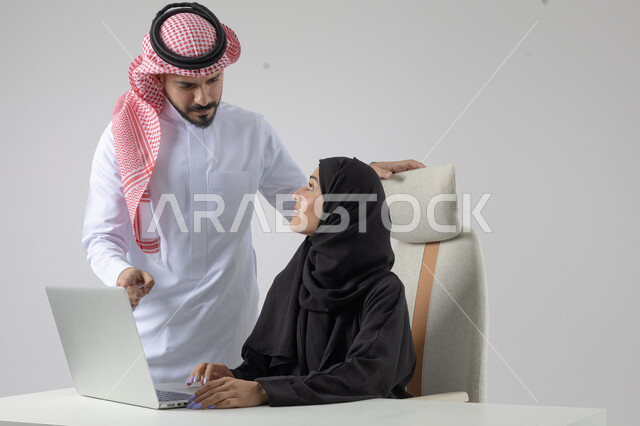  الوحده والعمل الجماعي، تبادل الاراء والخبرات، بورتريه لرجل وسيدة اعمال عربيان سعوديان خليجيان في مقر الشركة، ادارة العمل باستخدام الحاسب المحمول، تحقيق اهداف الشركة، مناقشة وتوزيع مهام العمل، تطوير العمل وحل المشكلات، مهن ووظائف سعودية مكتبية، خلفية بيضاء