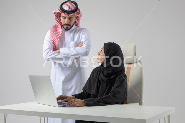  الوحده والعمل الجماعي، تبادل الاراء والخبرات، بورتريه لرجل وسيدة اعمال عربيان سعوديان خليجيان في مقر الشركة، ادارة العمل باستخدام الحاسب المحمول، تحقيق اهداف الشركة، مناقشة وتوزيع مهام العمل، تطوير العمل وحل المشكلات، مهن ووظائف سعودية مكتبية، خلفية بيضاء