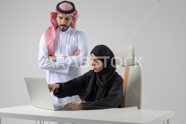  الوحده والعمل الجماعي، تبادل الاراء والخبرات، بورتريه لرجل وسيدة اعمال عربيان سعوديان خليجيان في مقر الشركة، ادارة العمل باستخدام الحاسب المحمول، تحقيق اهداف الشركة، مناقشة وتوزيع مهام العمل، تطوير العمل وحل المشكلات، مهن ووظائف سعودية مكتبية، خلفية بيضاء