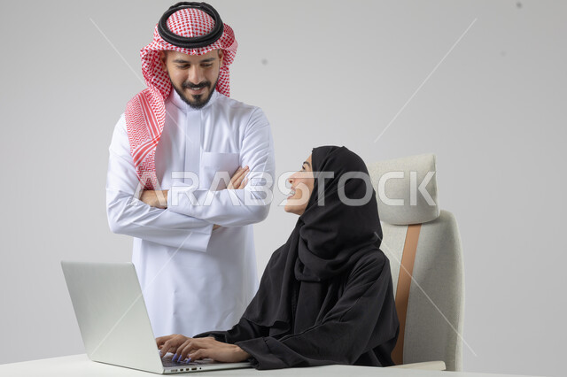  الوحده والعمل الجماعي، تبادل الاراء والخبرات، بورتريه لرجل وسيدة اعمال عربيان سعوديان خليجيان في مقر الشركة، ادارة العمل باستخدام الحاسب المحمول، تحقيق اهداف الشركة، مناقشة وتوزيع مهام العمل، تطوير العمل وحل المشكلات، مهن ووظائف سعودية مكتبية، خلفية بيضاء