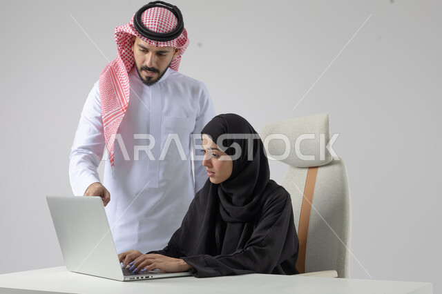  الوحده والعمل الجماعي، تبادل الاراء والخبرات، بورتريه لرجل وسيدة اعمال عربيان سعوديان خليجيان في مقر الشركة، ادارة العمل باستخدام الحاسب المحمول، تحقيق اهداف الشركة، مناقشة وتوزيع مهام العمل، تطوير العمل وحل المشكلات، مهن ووظائف سعودية مكتبية، خلفية بيضاء