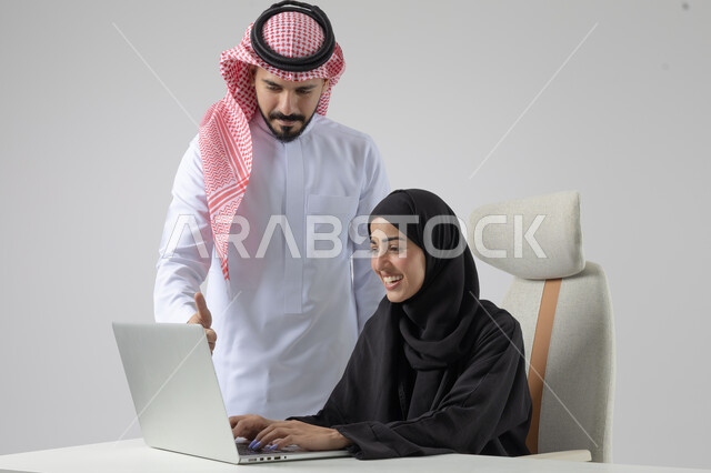  الوحده والعمل الجماعي، تبادل الاراء والخبرات، بورتريه لرجل وسيدة اعمال عربيان سعوديان خليجيان في مقر الشركة، ادارة العمل باستخدام الحاسب المحمول، تحقيق اهداف الشركة، مناقشة وتوزيع مهام العمل، تطوير العمل وحل المشكلات، مهن ووظائف سعودية مكتبية، خلفية بيضاء