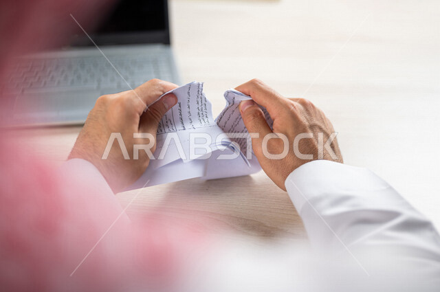 رجل عربي خليجي سعودي يقوم بتمزيق الاوراق، عدم الموافقة على العمل، صفقة غير ناجحة، رسالة غير مرغوبة، خطة عمل فاشلة