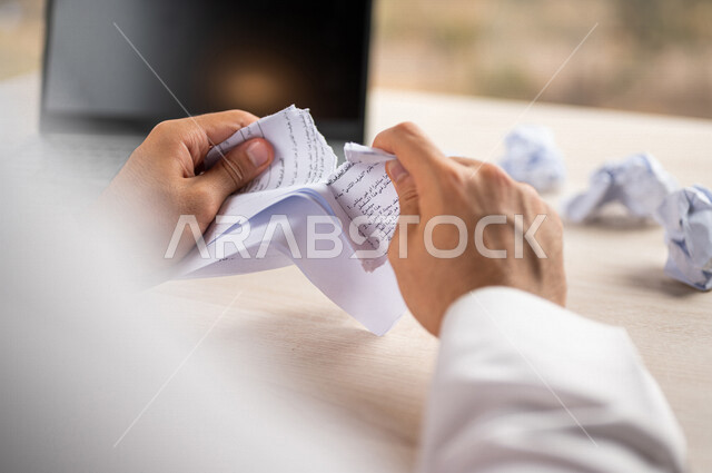 رجل عربي خليجي سعودي يقوم بتمزيق الاوراق، عدم الموافقة على العمل، صفقة غير ناجحة، رسالة غير مرغوبة، خطة عمل فاشلة