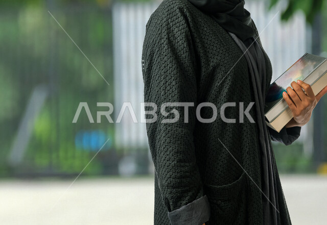 طالبة جامعية عربية سعودية خليجية تحمل الكتب الجامعية , الاستعداد للعام الدراسي الجامعي الجديد, تلميذة مجتهدة متشوقة للذهاب الى الجامعه, مدارس وجامعات, التعليم في المملكة العربية السعودية