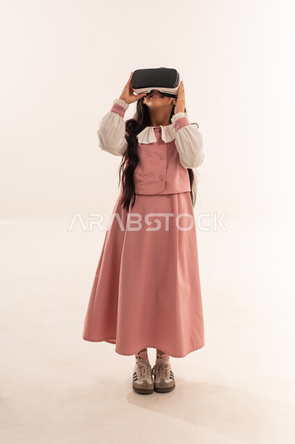 Advanced schools and academies, smart education via virtual reality glasses, combining learning with entertainment using modern technology, portrait of an Arab Gulf Omani student wearing a uniform and school bag, a Saudi student looking at something, full body, white background