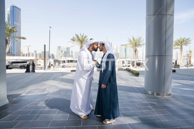 عادات العيد في المجتمع الاماراتي ، الوقوف بثقة في شوارع المدينة، قضاء أوقات ممتعة مع الاصدقاء ، صداقات وتعارف ونقاشات وحوارات ، رجلان عربيان خليجيان اماراتيان يتصافحان بحرارة، اجواء العيد، الاحتفال بالعيد السعيد، اعياد ومناسبات ، مفهوم الأناقة والاهتمام بالمظهر الخارجي .