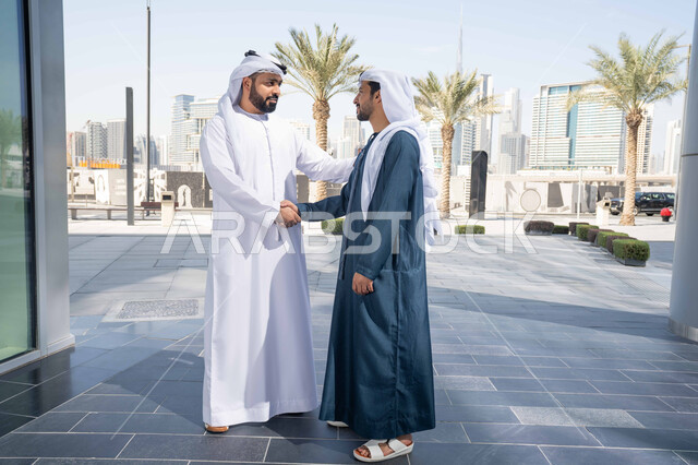 صداقات وتعارف ونقاشات وحوارات ، قضاء أوقات ممتعة مع الاصدقاء ، رجلان عربيان خليجيان اماراتيان يتصافحان بحرارة، اجواء العيد، عادات العيد في المجتمع الاماراتي ، العيد بين الأهل، بهجة العيد، زيارات العيد، الاحتفال بالعيد السعيد، اعياد ومناسبات مفهوم الأناقة والاهتمام بالمظهر الخارجي .