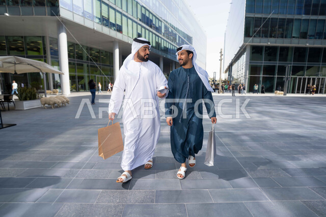 ايماءات وتعابير السعادة ، شراء الهدايا والمستلزمات ، قضاء أوقات ممتعة في الطبيعة ، التجول واستنشاق الهواء النقي في وقت النهار، صداقات وتعارف ونقاشات وحوارات ، صديقان عربيان خليجيان اماراتيان يرتديان الكندورة والغترة البيضاء ،  يحملان اكياس التسوق بتعابير السرور.