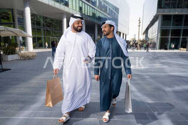 شراء الهدايا والمستلزمات ، قضاء أوقات ممتعة في الطبيعة ، التجول واستنشاق الهواء النقي في وقت النهار، صداقات وتعارف ونقاشات وحوارات ، صديقان عربيان خليجيان اماراتيان يرتديان الكندورة والغترة البيضاء ،  يحملان اكياس التسوق بتعابير السرور.