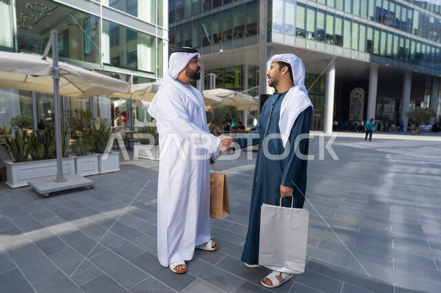 رجلان عربيان خليجيان اماراتيان يتصافحان بحرارة، بهجة العيد، الاحتفال بالعيد السعيد، اجواء العيد، العيد مع الاصدقاء ، عادات العيد في المجتمع الاماراتي ، صداقات وتعارف ونقاشات وحوارات قضاء أوقات ممتعة في الطبيعة ، زيارات العيد، اعياد ومناسبات .
