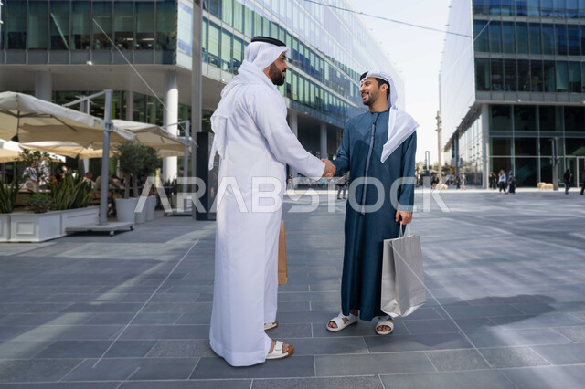 اجواء العيد، العيد مع الاصدقاء ، عادات العيد في المجتمع الاماراتي ، صداقات وتعارف ونقاشات وحوارات قضاء أوقات ممتعة في الطبيعة ، رجلان عربيان خليجيان اماراتيان يتصافحان بحرارة، بهجة العيد، زيارات العيد، الاحتفال بالعيد السعيد، اعياد ومناسبات .