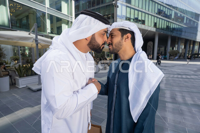 صداقات وتعارف ونقاشات وحوارات قضاء أوقات ممتعة في الطبيعة ، رجلان عربيان خليجيان اماراتيان يتصافحان بحرارة، اجواء العيد، عادات العيد في المجتمع الاماراتي ، العيد بين الأهل، بهجة العيد، زيارات العيد، الاحتفال بالعيد السعيد، اعياد ومناسبات .