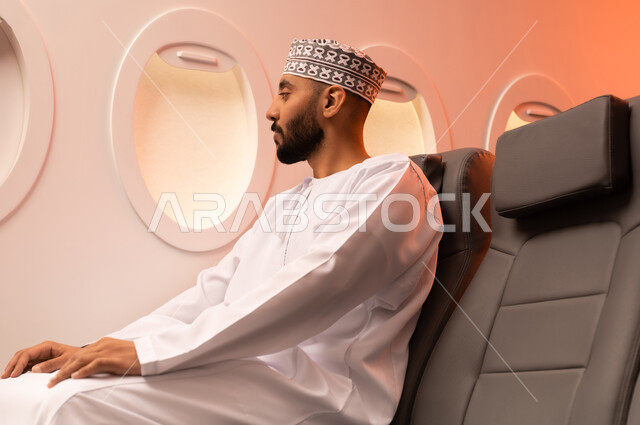 الجلوس بأدب وسكينه داخل الطائره, بورتريه مقرب من الجانب لرجل عربي خليجي عماني يرتدي الدشداشة والكمة يجلس على مقعد داخل الطائره السياحيه الخليجيه العمانيه منتظرا موعد وصول الطائره,  الطيران الخليجي العماني