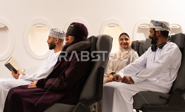 قضاء أوقات ممتعة داخل الطائرة ، بورتريه مقرب من الجانب لمسافرون من العرب العمانيون الخليجيون داخل مقصورة الطائرة يرتدون الزي العماني، ايماءات تدل على الفرح والسعادة ، رحلات سياحية جويه ممتعة، عطلة صيفية عائلية، الخطوط الجوية العمانيه، سياحة وسفر