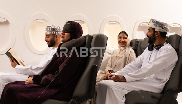 قضاء أوقات ممتعة داخل الطائرة ، بورتريه مقرب من الجانب لمسافرون من العرب العمانيون الخليجيون داخل مقصورة الطائرة يرتدون الزي العماني، ايماءات تدل على الفرح والسعادة ، رحلات سياحية جويه ممتعة، عطلة صيفية عائلية، الخطوط الجوية العمانيه، سياحة وسفر