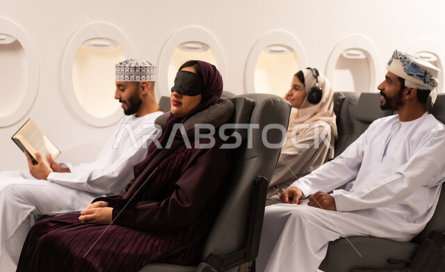 قضاء أوقات ممتعة داخل الطائرة ، بورتريه مقرب من الجانب لمسافرون من العرب العمانيون الخليجيون داخل مقصورة الطائرة يرتدون الزي العماني، ايماءات تدل على الفرح والسعادة ، رحلات سياحية جويه ممتعة، عطلة صيفية عائلية، الخطوط الجوية العمانيه، سياحة وسفر