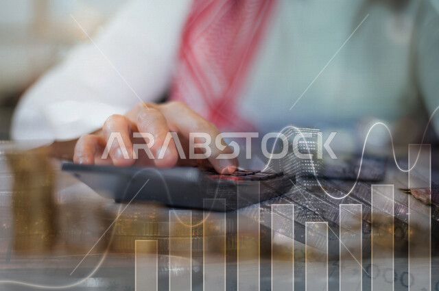 صورة مقربة لرجل عربي سعودي خليجي محاسب يستخدم الآلة الحاسبة للتعبير عن الإحصائيات والحسابات , العمل في إدارة الحسابات , الإستثمار المالي , الحسابات البنكية .