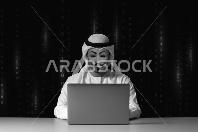Stealing confidential data, hacking systems and protecting devices, being exposed to attacks and hacks, close-up silhouette of a Saudi Arabian Gulf man wearing a white thobe and a Saudi shemagh using a laptop for illegal hacking