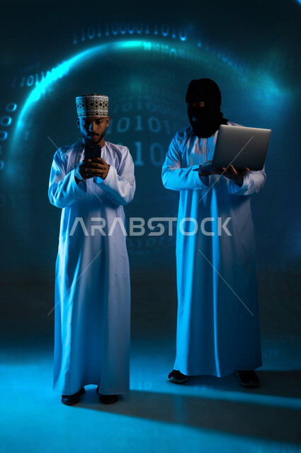 Cybersecurity intrusion, use of computer for illegal purposes, hacking and data theft, algorithms to destroy digital accounts, two masked Omani Gulf Arab hackers wearing dishdashas working in the field of digital piracy, full body