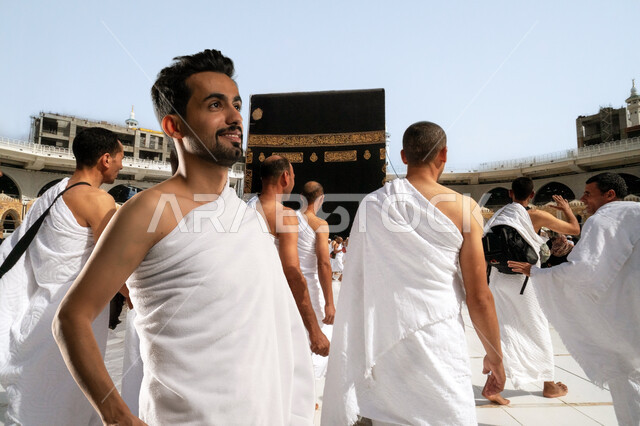 حجاج بيت الله الحرام يطوفون حول الكعبة المشرفة في الحرم المكي الشريف في مكة المكرمة بالمملكة العربية السعودية، أداء مناسك الحج والعمرة، العبادة والتقرب إلى الله تعالى في الأماكن الإسلامية المقدسة, رجل عربي خليجي سعودي يرتدي ملابس الاحرام يقوم بالطواف حول الكعبه