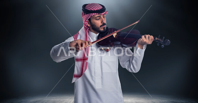 صورة مقربة لرجل عربي سعودي خليجي يعزف على آلة الكمان بخلفية سوداء , آلات موسيقية ,  مواهب فنية , فنون موسيقية .