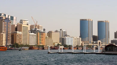 The towers and skyscrapers of the United Arab Emirates overlooking the Arabian Gulf coast, the advanced architecture of the commercial facilities in Dubai Marina, a famous coastal landmark and tourist destination, the yacht port and marine transportation during the day