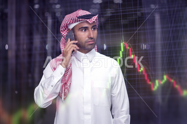 A Saudi Arabian Gulf man using a mobile phone to make a business call, follow the stock market chart, monitor the rise and fall of the stock market, investment and trading in the stock market, the economy and financial growth, chart background