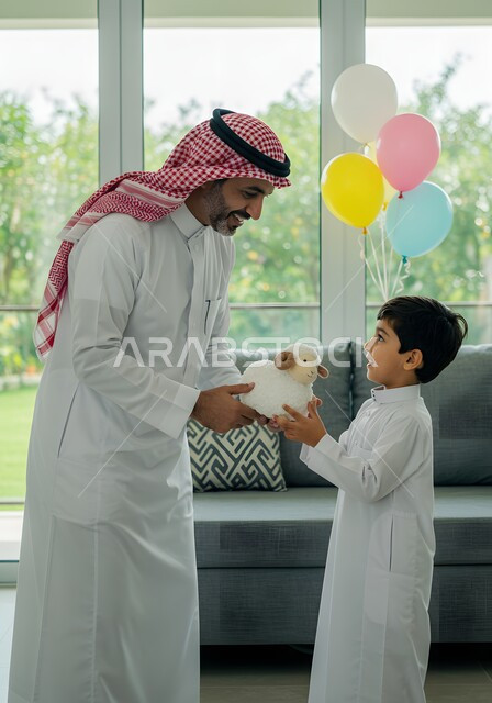 التسامر والضحك مع الابناء في عيد الاضحى المبارك، رجل عربي خليجي سعودي يرتدي الشماغ والثوب التقليدي يعطي ابنه دمية على شكل خاروف عيد الاضحى، التزيين في الاعياد والمناسبات العائليه, ايماءات السعادة والسرور