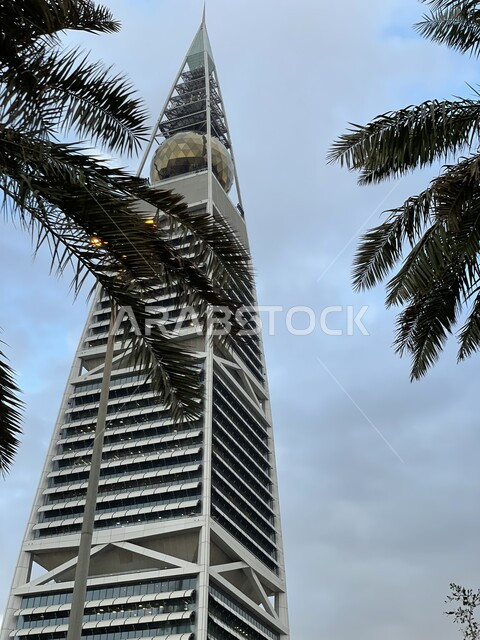 برج الفيصلية في العاصمة الرياض في النهار، التطور والتقدم العمراني للمنشأت في المملكة العربية السعودية، التصاميم الهندسية المعمارية على الطراز الحديث والمتطور، منظر السماء الزرقاء الصافية، مكان سياحي مشهور، الفن الهندسي للابراج وناطحات السحاب