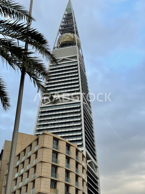 برج الفيصلية في العاصمة الرياض في النهار، التطور والتقدم العمراني للمنشأت في المملكة العربية السعودية، التصاميم الهندسية المعمارية على الطراز الحديث والمتطور، منظر السماء الزرقاء الصافية، مكان سياحي مشهور، الفن الهندسي للابراج وناطحات السحاب