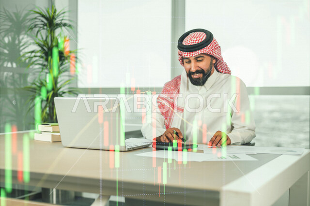رجل عربي خليجي سعودي يجلس امام الحاسوب المحمول  ،  محاسب يستخدام الالة الحاسبة لحساب الارباح والخسائر ، اعداد التقارير المالية وتحليل البيانات المالية ،إدارة الحسابات ،  خلفية المخطط البياني