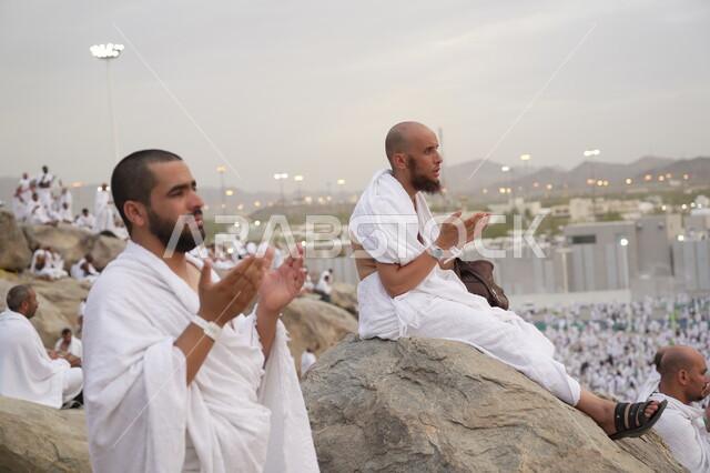 حاج يرتدي لباس الاحرام يقف على جبل عرفات، مفهوم العبادة والتقرب إلى الله، الحجاج والمعتمرين في مكة المكرمة، آدء مناسك الحج في يوم عرفة, مقصد المسلمين من أنحاء العالم, مكان ومعلم إسلامي ديني مقدس في المملكة العربية السعودية، موسم الحج 2025
