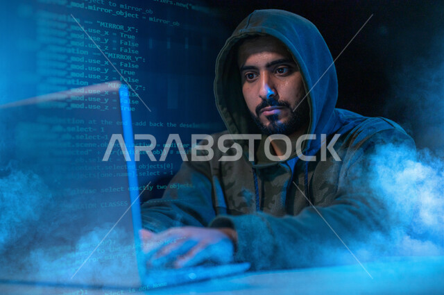 رجل عربي خليجي سعودي يستخدم الحاسوب المحمول ،يعمل على اختراق حماية وأمن وبيانات المستخدمين، استخدم جهاز الحاسوب في الهجمات السيبرانية، الجرائم الالكترونية