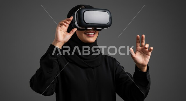 Using modern and advanced technologies, digital transformation and technological progress, gestures of integration and focus in virtual reality, close-up portrait of a veiled Saudi Arabian Gulf woman wearing an abaya and VR glasses, gray background