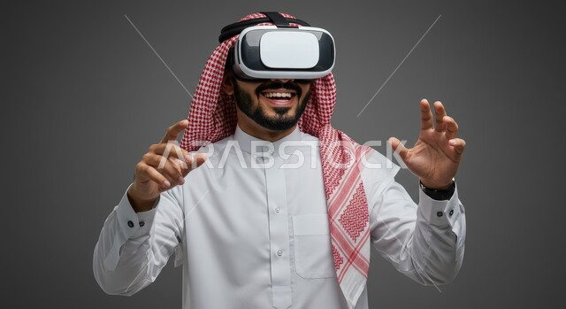 Integration and interaction with virtual reality, feeling fun and entertainment by simulating the imaginary world, technological devices and modern technologies, close-up portrait of a Saudi Arabian Gulf man wearing a traditional shemagh and thobe, wearing 3D VR glasses with gestures of pleasure and joy, gray background