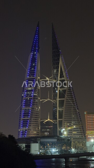 مركز البحرين التجاري العالمي المطل على البحر في الليل، الفن الهندسي المعماري للأبراج والمباني وناطحات السحاب في المنامة، أماكن سياحية مشهورة، النمو والتقدم العمراني في العاصمة، التصاميم الهندسية المعمارية على الطراز الحديث والمتطور 