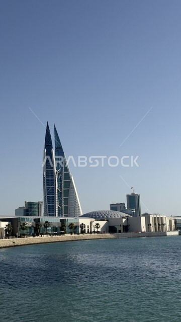 مركز البحرين التجاري العالمي المطل على البحر في النهار، الفن الهندسي المعماري للأبراج والمباني وناطحات السحاب في المنامة، أماكن سياحية مشهورة، النمو والتقدم العمراني في العاصمة، التصاميم الهندسية المعمارية على الطراز الحديث والمتطور 