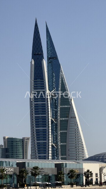 مركز البحرين التجاري العالمي المطل على البحر في النهار، الفن الهندسي المعماري للأبراج والمباني وناطحات السحاب في المنامة، أماكن سياحية مشهورة، النمو والتقدم العمراني في العاصمة، التصاميم الهندسية المعمارية على الطراز الحديث والمتطور 