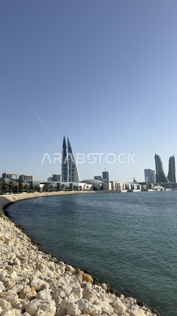 مركز البحرين التجاري العالمي المطل على البحر في النهار، الفن الهندسي المعماري للأبراج والمباني وناطحات السحاب في المنامة، أماكن سياحية مشهورة، النمو والتقدم العمراني في العاصمة، التصاميم الهندسية المعمارية على الطراز الحديث والمتطور 