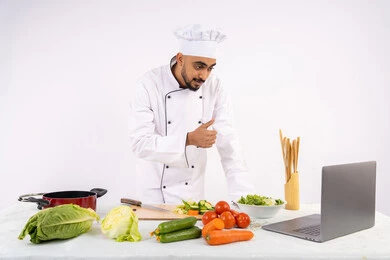 رفع اصبع الابهام للأعلى بإيماءات الإعجاب، تعلم فنون الطهي من خلال المواقع الإلكترونية عبر الحاسوب، توعية المجتمع بإعداد الطعام الصحي، بورتريه لرجل عربي خليجي اماراتي يرتدي زي العمل يقوم بتصوير وعرض الطبخ عبر اللابتوب، شيف سعودي يحضر وصفة عبر بث مباشر، خلفية بيضاء