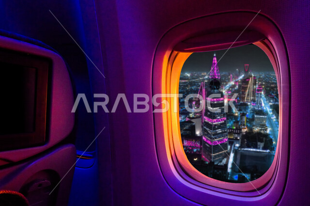 صورة لنافذة الطائرة تطل على برج الفيصلية في حي العليا في مدينة الرياض في المملكة العربية السعودية ، صورة جوية رائعة من داخل الطائرة لمدينة الرياض ليلا ، ابراج وناطحات سحاب في السعودية