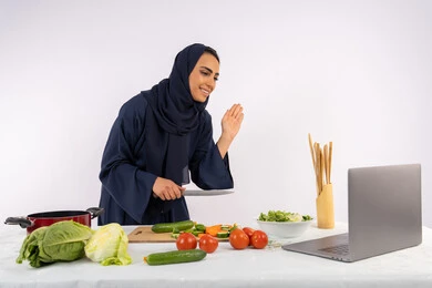 إعداد الطعام الصحي، إلقاء التحية والسلام، تعلم وتطبيق فنون الطهي من خلال المواقع الإلكترونية، بورتريه لامرأة عربية خليجية اماراتية محجبة ترتدي العباءة تقوم بتصوير وعرض الطبخ عبر اللابتوب، ربة منزل سعودية تشرح المكونات والكميات المطلوبة عبر بث مباشر، خلفية بيضاء