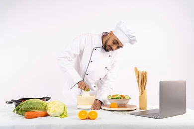 نشر ومشاركة الوصفات على مواقع الانترنت، شيف سعودي يقوم بتحضير عصير مفيد، تعلم مهارة الطهي عبر الحاسوب المحمول، مفهوم النظام الغذائي الصحي، اعداد المشروبات الصحية والطازجة، بورتريه لرجل عربي خليجي اماراتي يرتدي زي الطهاة يعصر البرتقال الطازج، خلفية بيضاء