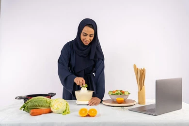 المشروبات الصحية والمنعشة، اتباع نظام غذائي صحي، تعلم مهارة الطهي باستخدام الحاسوب، بورتريه لسيدة عربية خليجية اماراتية محجبة ترتدي عباءة تقوم بعصر الليمون، ربة منزل سعودية تقوم بتحضير طبق مفيد، مشاركة الوصفة عبر مواقع التواصل الاجتماعي، خلفية بيضاء